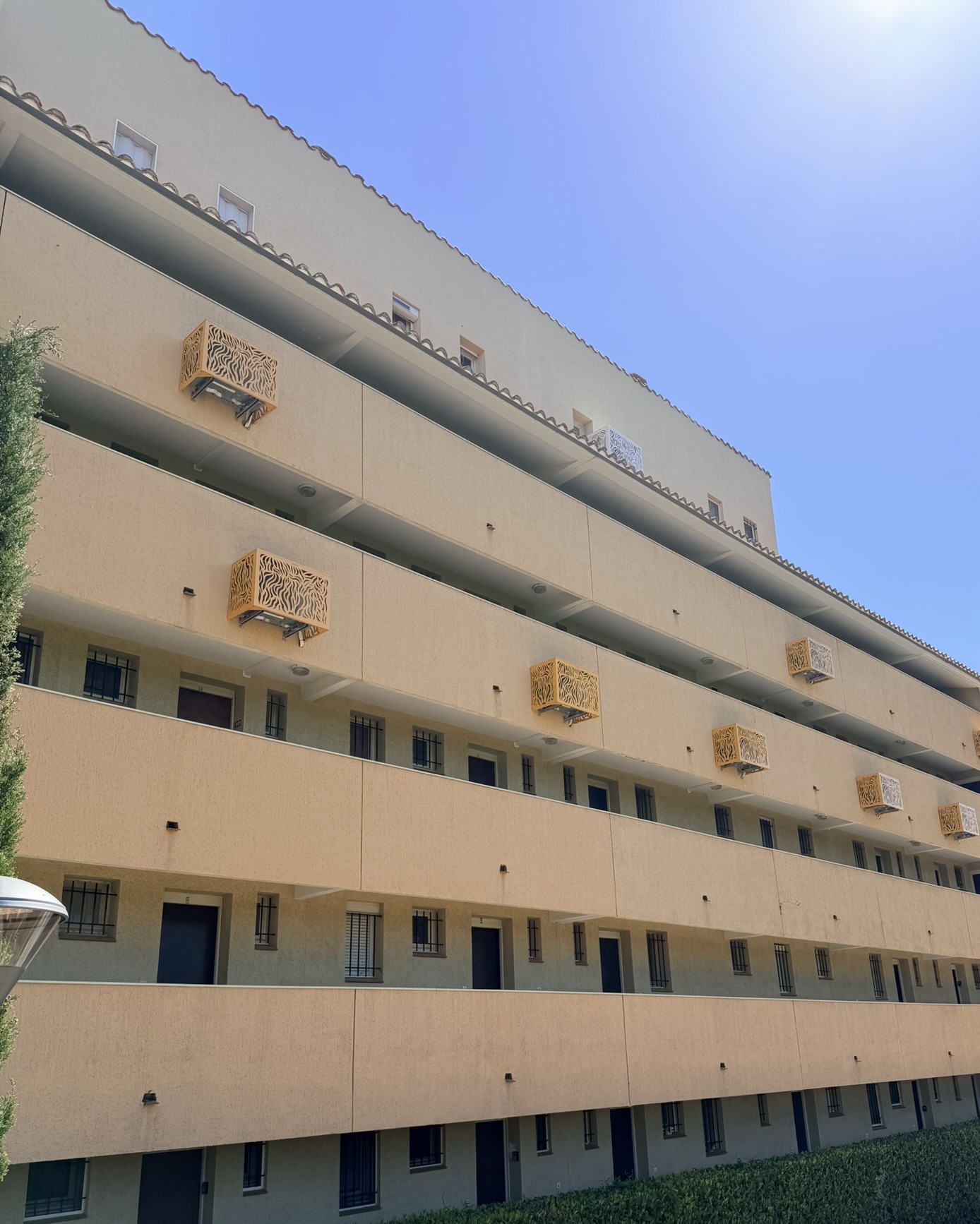 Résidence d'Argelès-sur-Mer climatisée, cache-clim visibles en façade au coucher du soleil