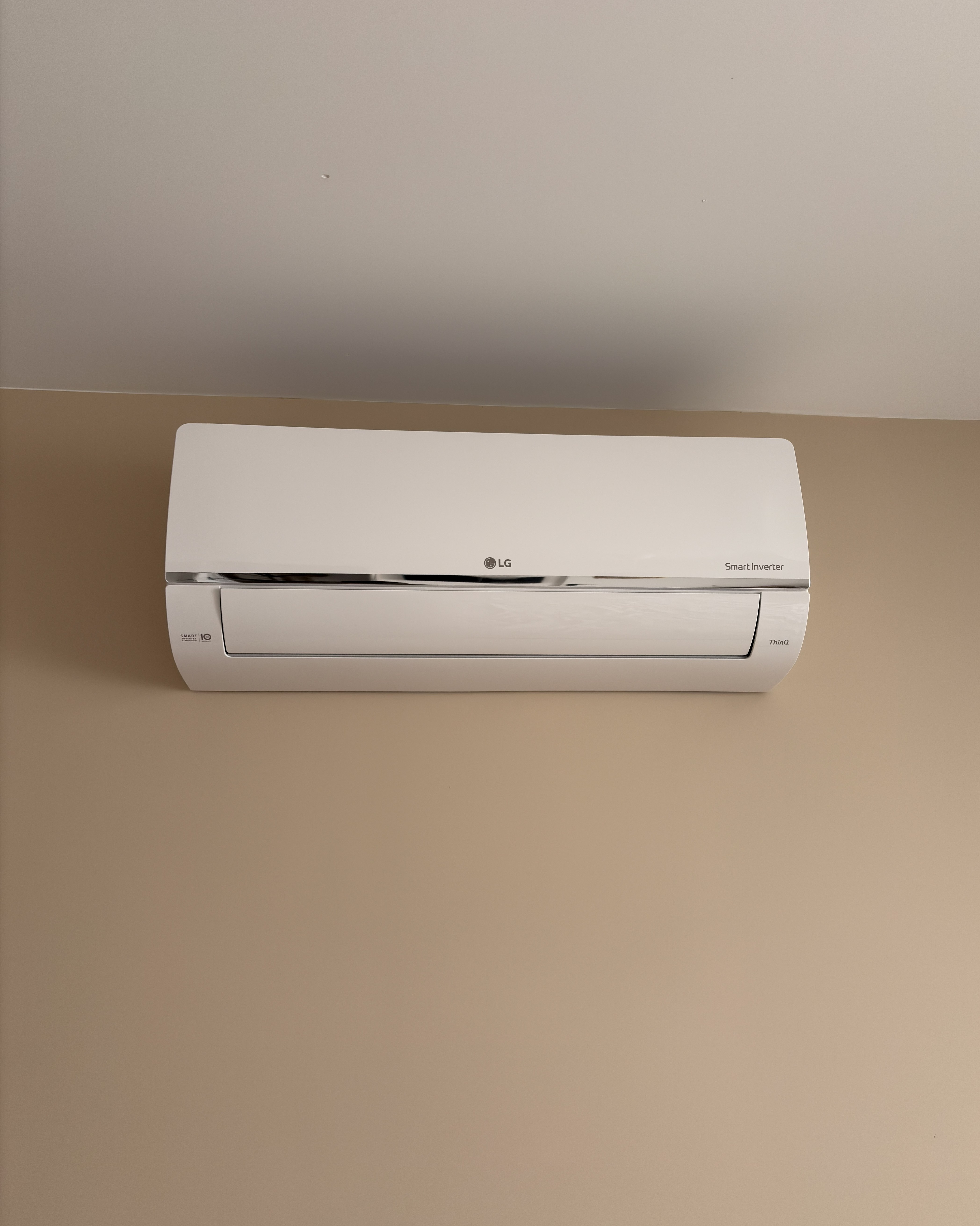 Unité murale de climatisation LG Standard Plus blanche installée dans une chambre