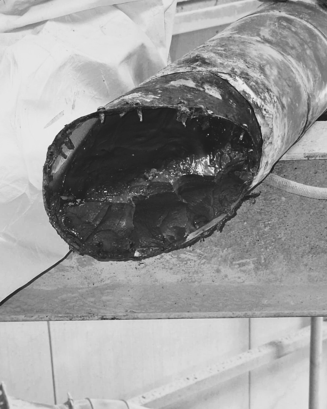 Intérieur d'un réseau industriel encrassé par des dépôts de graisse avant nettoyage