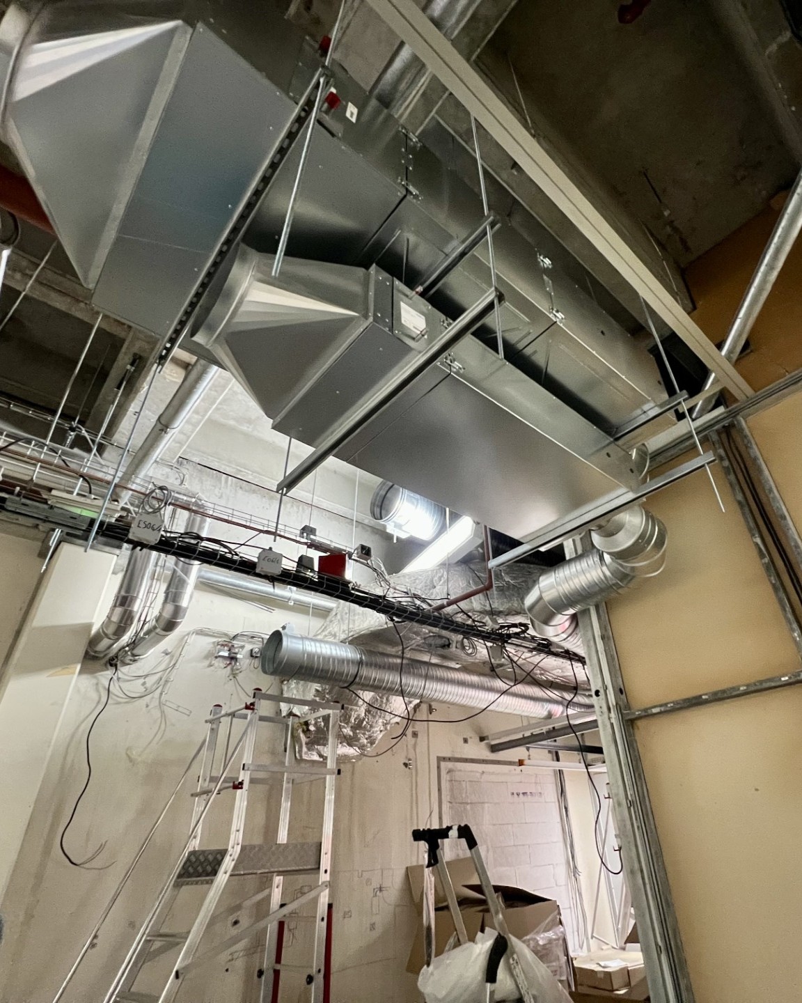 Réseau de gaines techniques et câblage installé en faux plafond d'une salle propre pharmaceutique